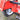 A rearview perspective of a red forecart, showing the inside of a square fender and a pneumatic tire and its left-hand mechanical disc brake assembly. Pneumatic tires allow for a more comfortable ride.