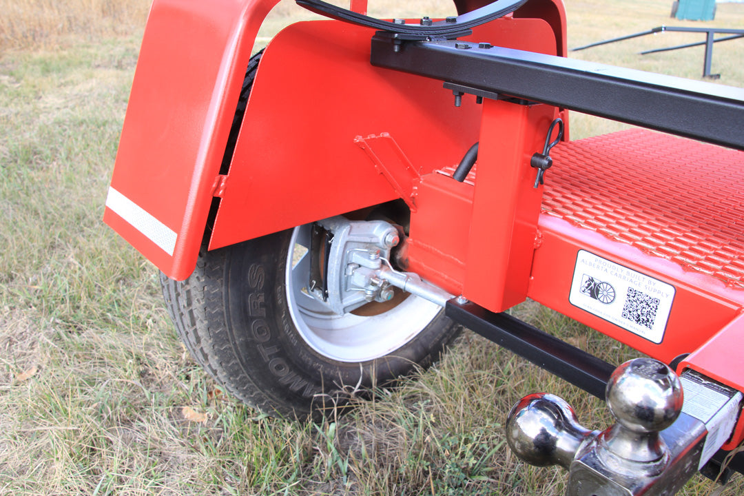 A rearview perspective of a red forecart, showing the inside of a square fender and a pneumatic tire and its left-hand mechanical disc brake assembly. Pneumatic tires allow for a more comfortable ride.